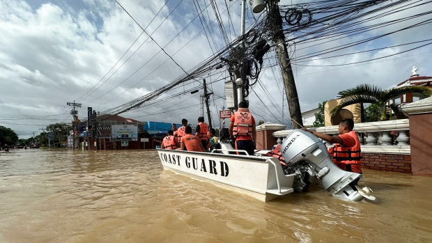 In this photo provided by the Philippine Coast Guard, rescuers ride a boat around the flooded town of Nabua, Camarines Sur, Philippines on Friday, Oct. 25, 2024. (Philippine Coast Guard via AP)