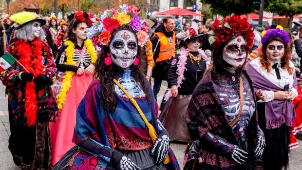 People take part in the traditional Catrina parade marking the Day of the Dead in front of the Old Opera in Frankfurt, Germany, Saturday, Nov. 2, 2024. (AP Photo/Michael Probst)