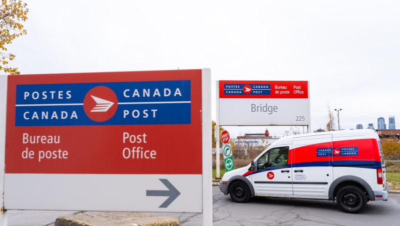 A Canada Post delivery truck leaves their depot in Montreal on Monday, Nov. 4, 2024. (THE CANADIAN PRESS/Christinne Muschi)