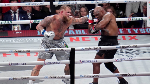 Jake Paul hits Mike Tyson during their heavyweight boxing match, Friday, Nov. 15, 2024, in Arlington, Texas. (AP Photo/Julio Cortez)