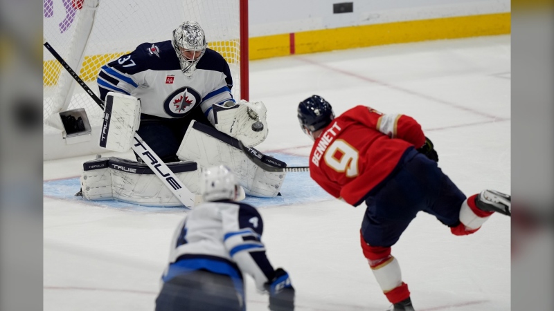 Winnipeg Jets goaltender Connor Hellebuyck (37) defends a shot on the goal by Florida Panthers center Sam Bennett (9) during the third period of an NHL hockey game, Nov. 16, 2024, in Sunrise, Fla. (Lynne Sladky/Associated Press)