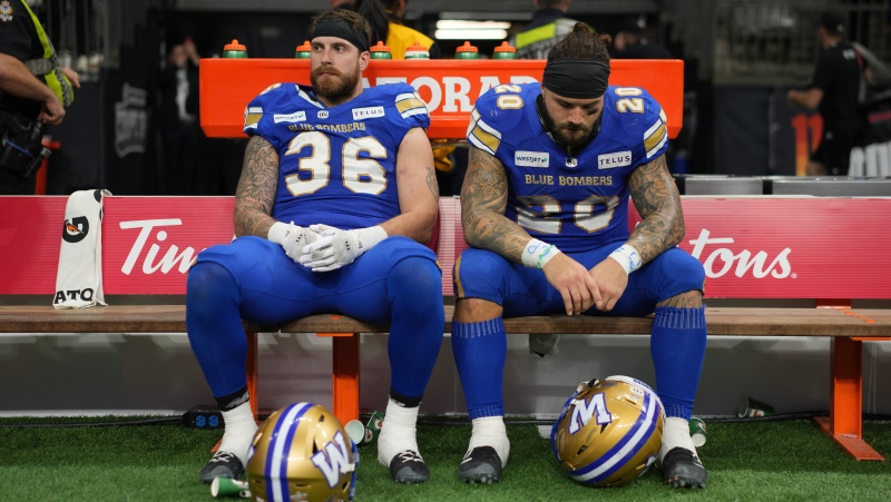 Winnipeg Blue Bombers' Bailey Feltmate (36) and teammate Brady Oliveira (20) sit on the bench after losing the 111th Grey Cup to the Toronto Argonauts, in Vancouver, B.C., Sunday, Nov. 17, 2024. (Ethan Cairns/The Canadian Press)