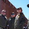 Homeland Security Secretary Kristi Noem listens during a tour along the Nogales border wall at the Mariposa Port of Entry in Nogales, Arizona, on March 15.