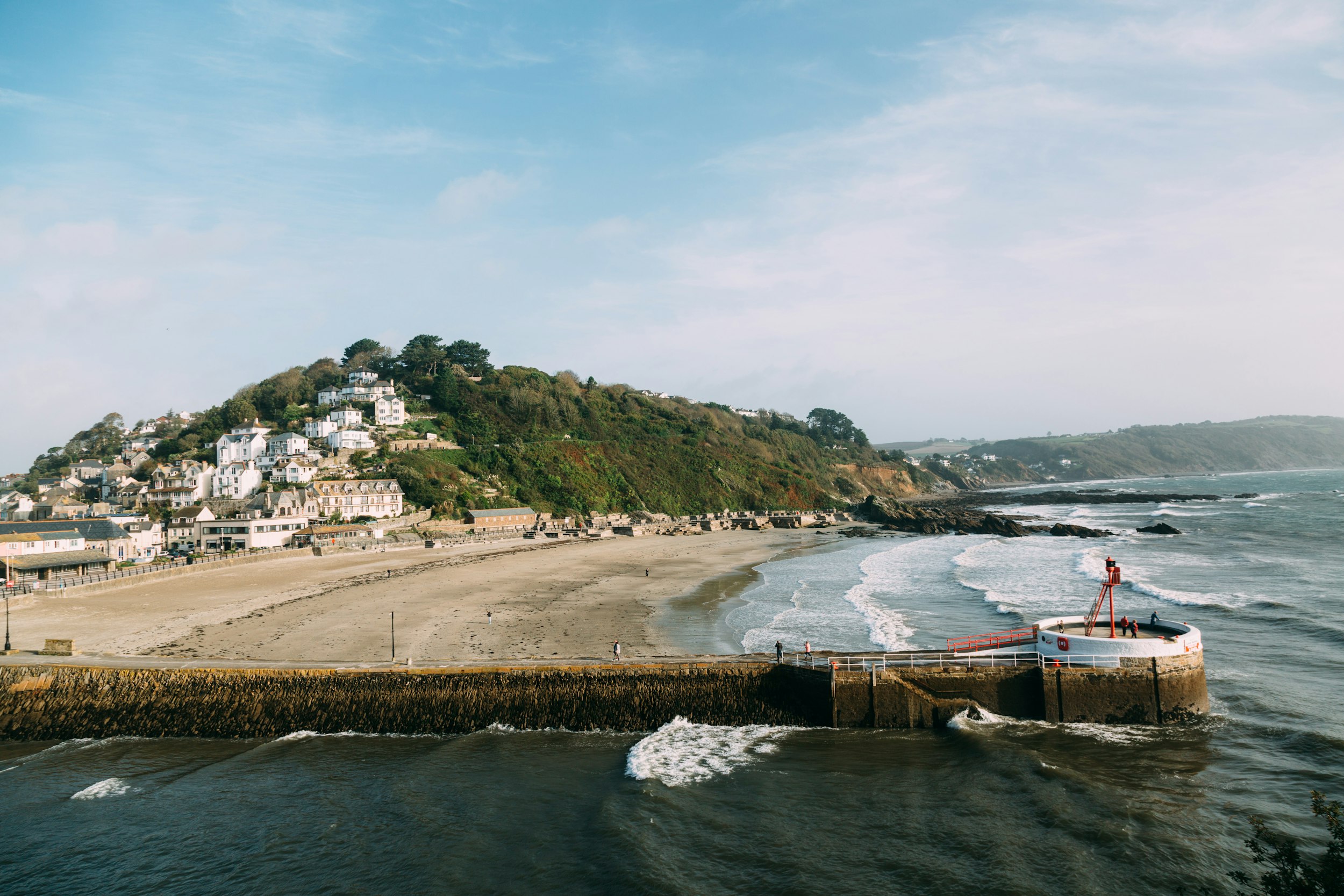 a view of a beach with a small hill in the background