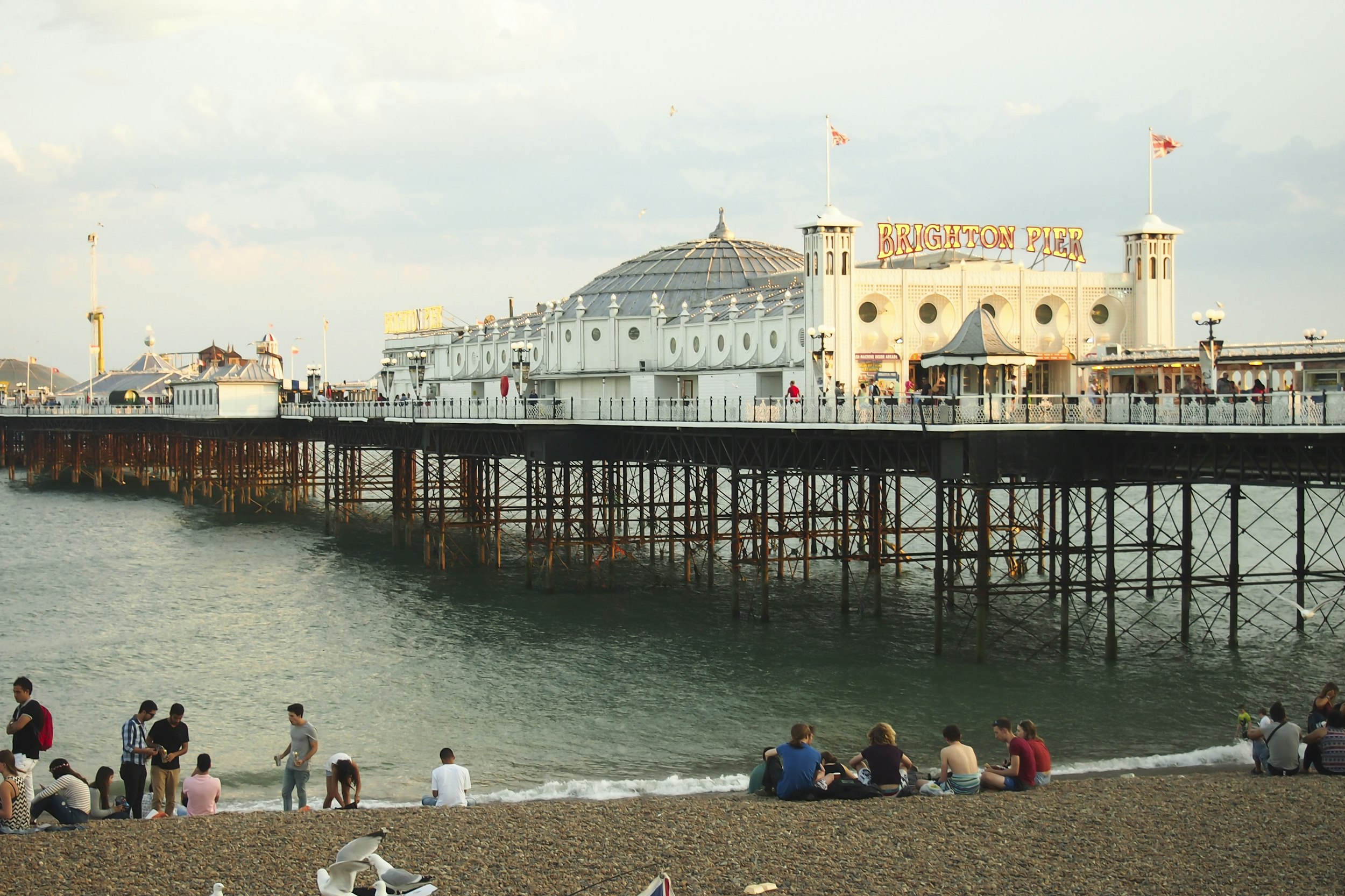 people sitting on beach near white concrete building during daytime