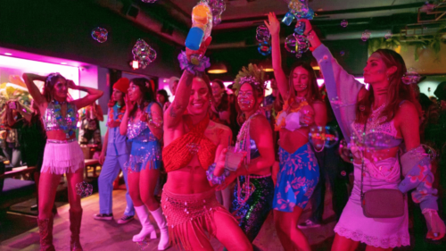 Women dressed up blowing bubbles