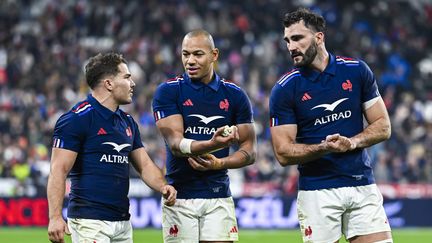 Antoine Dupont, Gaël Fickou et Charles Ollivon en discussion après le match face à la Nouvelle-Zélande, le 16 novembre 2024. (VICTOR JOLY / AFP)