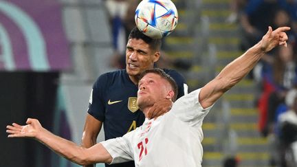 Tête du Français Raphaël Varane contre le Danois Andreas Cornelius, pendant la Coupe du monde 2022 au Qatar. (NATALIA KOLESNIKOVA / AFP)