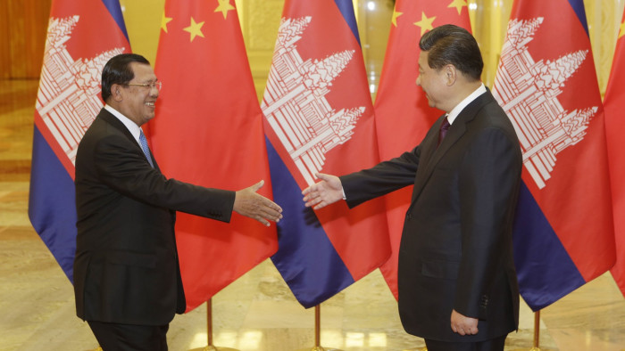 BEIJING, CHINA - NOVEMBER 7: Cambodia's Prime Minister Hun Sen (L) stretches to shake hands with China's President Xi Jinping before a meeting at the Great Hall of the People on November 7, 2014 in Beijing, China. (Photo by Jason Lee - Pool/Getty Images)