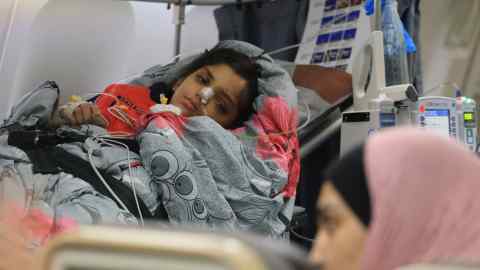 A Palestinian child on a stretcher and hooked up to machines to measure her vital signs