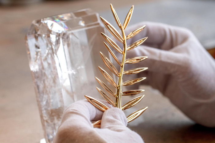 An artisan affixes the the Palme dOr onto a crystal trophy in their workshop