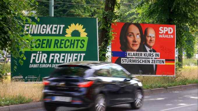 Car drives by election signs in Berlin, Germany