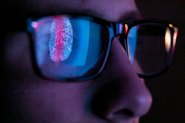 reflection in spectacles  of access information being scanned on computer screen, close up of face