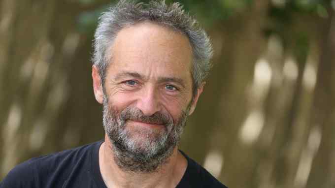 A smiling man with grey hair and beard