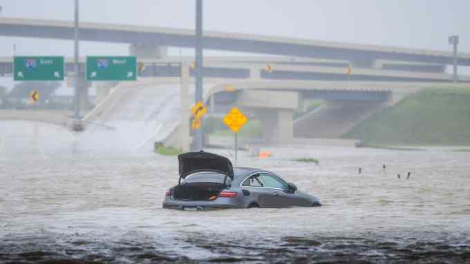 A vehicle abandoned in flood water on a highway after Hurricane Beryl swept through Houston