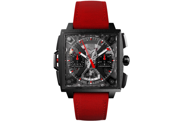 a luxury watch with a square-shaped case and red strap. It has a black dial, white hands and markers, accentuated with red and white colours