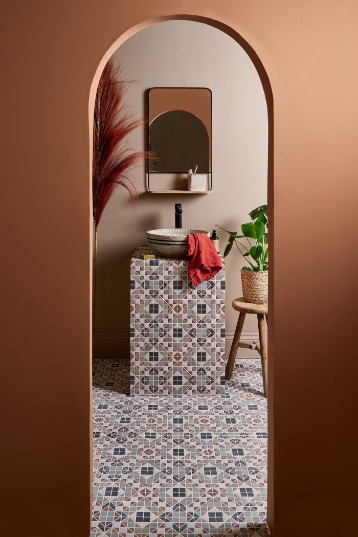 This arched doorway is painted in Ca’Pietra’s Pavilion Russet Red (£65 for 2.5l) to frame the focal point of the space – a vanity unit clad in the brand’s geometric Pavilion tiles (£77.62 for box of 10). Rose-tinted Edith’s Pampas paint is washed over the backdrop for contrast