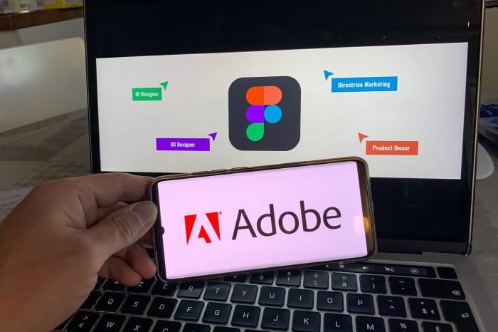 A smart phone displays the Adobe logo on its screen, next to a computer displaying the Figma logo