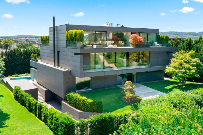 modernist house with outdoor terraces surrounded by greenery