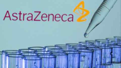 Test tubes are seen in front of the AstraZeneca logo