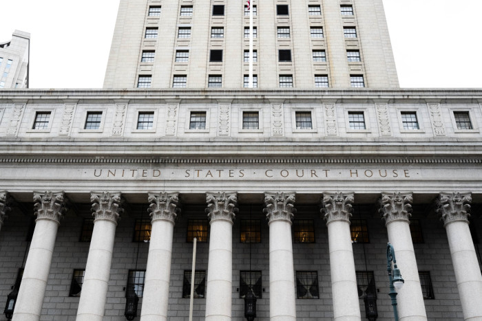 Close-up view of the entrance to a U.S. Courthouse, highlighted by classical architectural columns and a frieze with the building’s name engraved on it