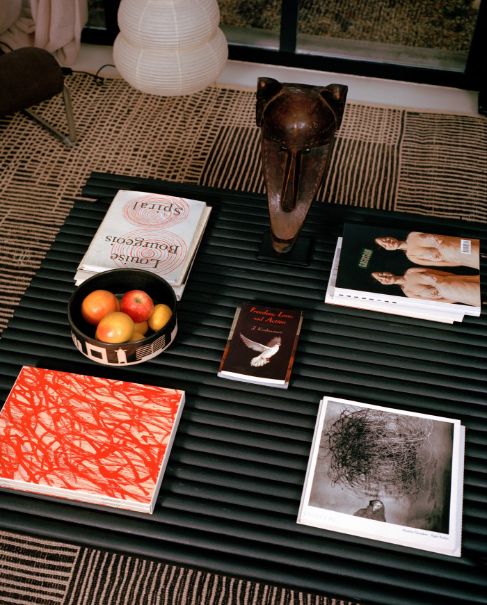 Art books on Louise Bourgeois and Cy Twombly, with a hyena mask from Mali