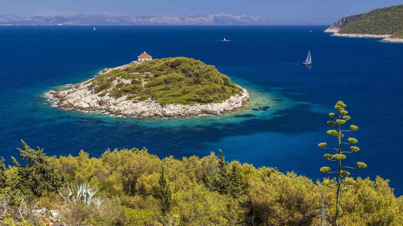 A large building on a small island in blue sea