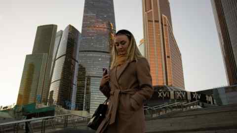 A woman walks past the business district in Moscow