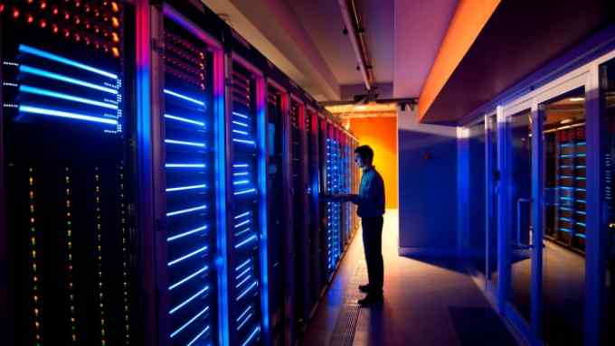 Modern interior of server room in datacenter. IT Engineer in Action Configuring Servers