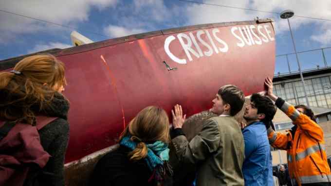 Protesters demonstrate with a boat at the entrance of Swiss bank Credit Suisse during the annual shareholders’ meeting of the Swiss banking group, in Zurich