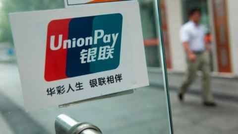 The China UnionPay logo is displayed in the window of a business in Beijing, China