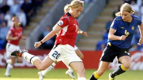 Professional women football players in action, competing for possession and control of the ball