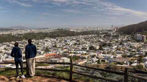 Two people looking out over a residential area in San Francisco, their backs to the camera