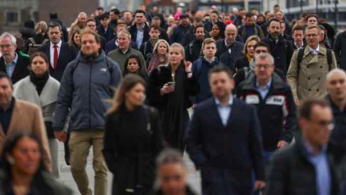 Commuters cross London Bridge in the City of London