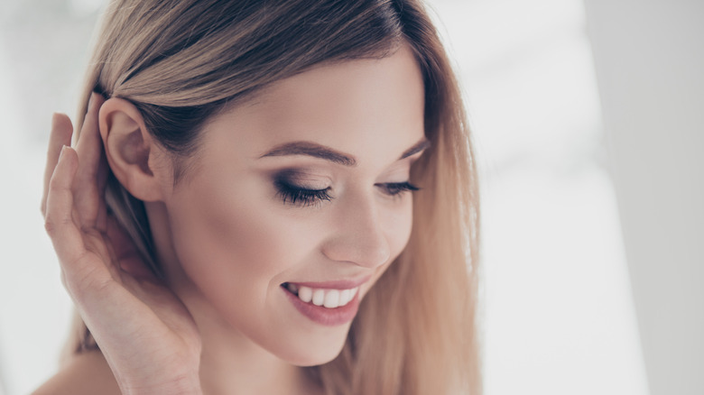 Woman showing ear smokey eye