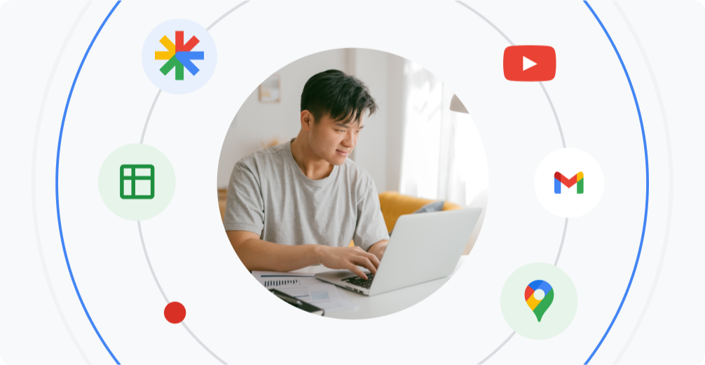 A young man uses a laptop. He’s encircled by the logos of Google products.