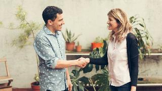 A man and a woman shaking hands, presumably meeting for the first time.