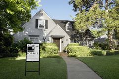 Exterior view of house with for sale sign, from front lawn