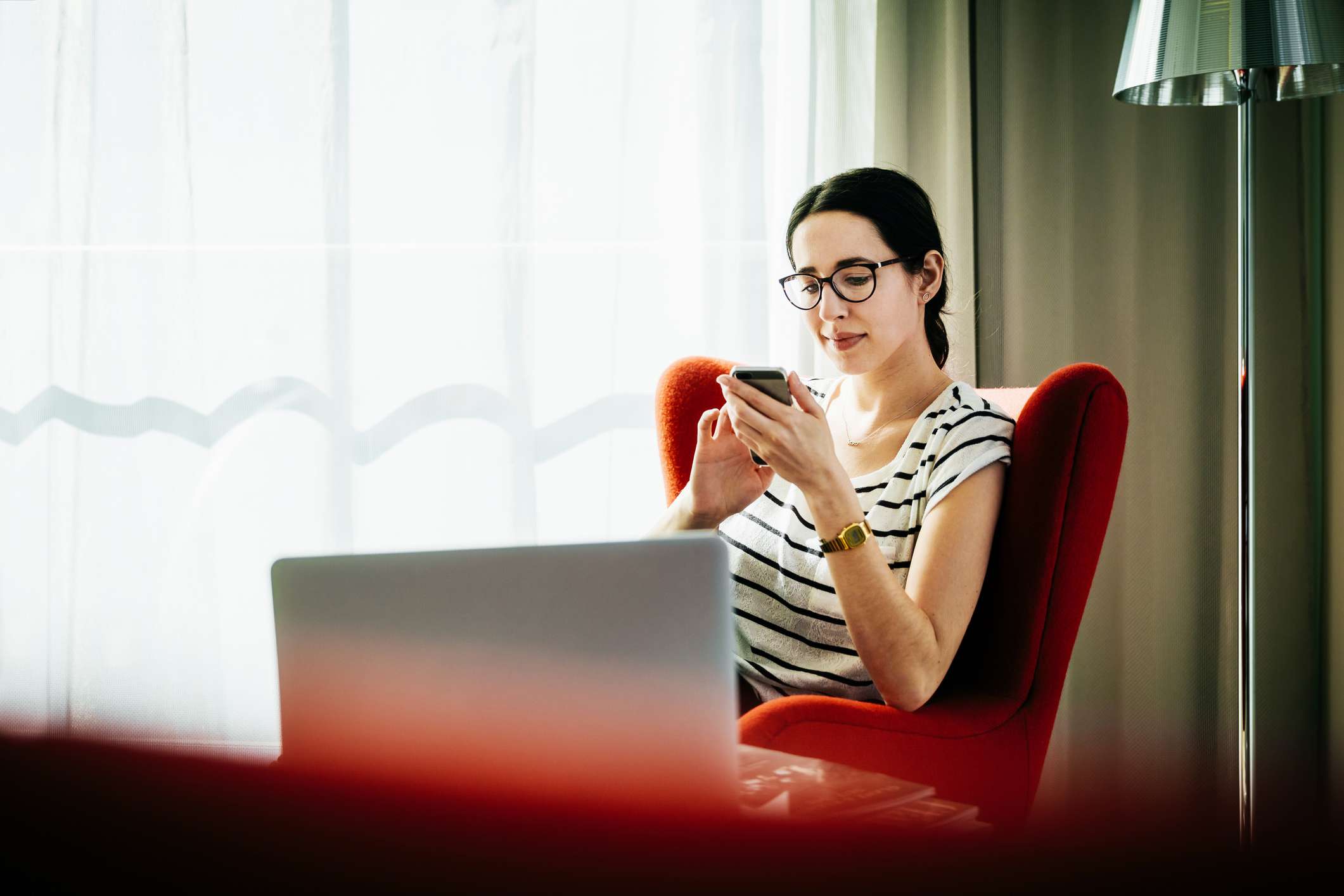 A woman scrolls through a mobile phone.