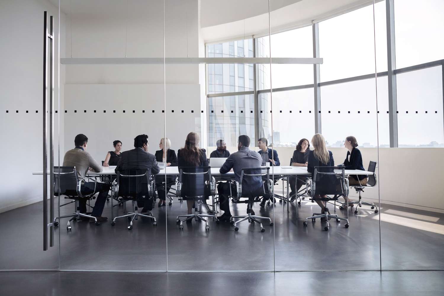 The executive team of a company at a conference table discussing their takeover strategy and funding.