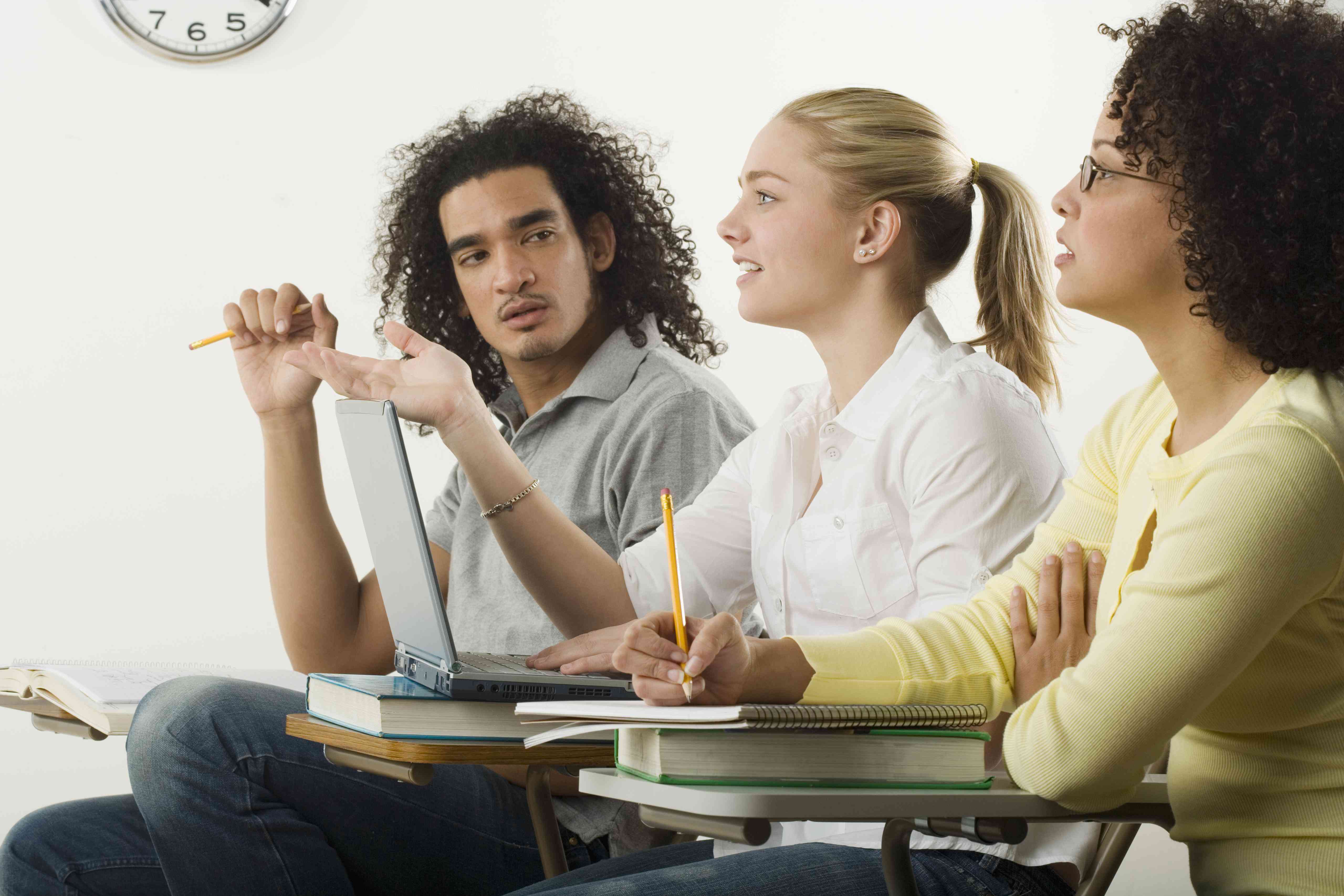 Three college kids - two women and a man - in a classroom setting.