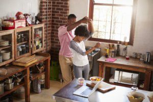 A couple dancing in the kitchen.