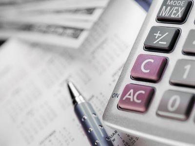 Close-up of a calculator and a pen on a calendar