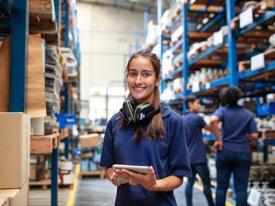 Smiling female warehouse worker holding a tablet