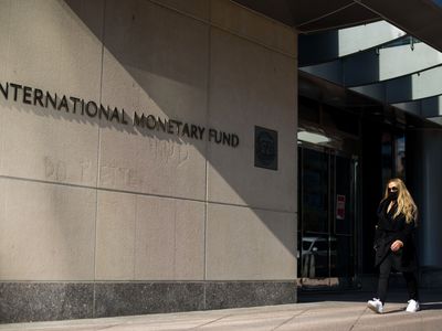 A woman walking past an International Monetary Fund building.