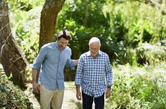 A father and son walk in the woods.