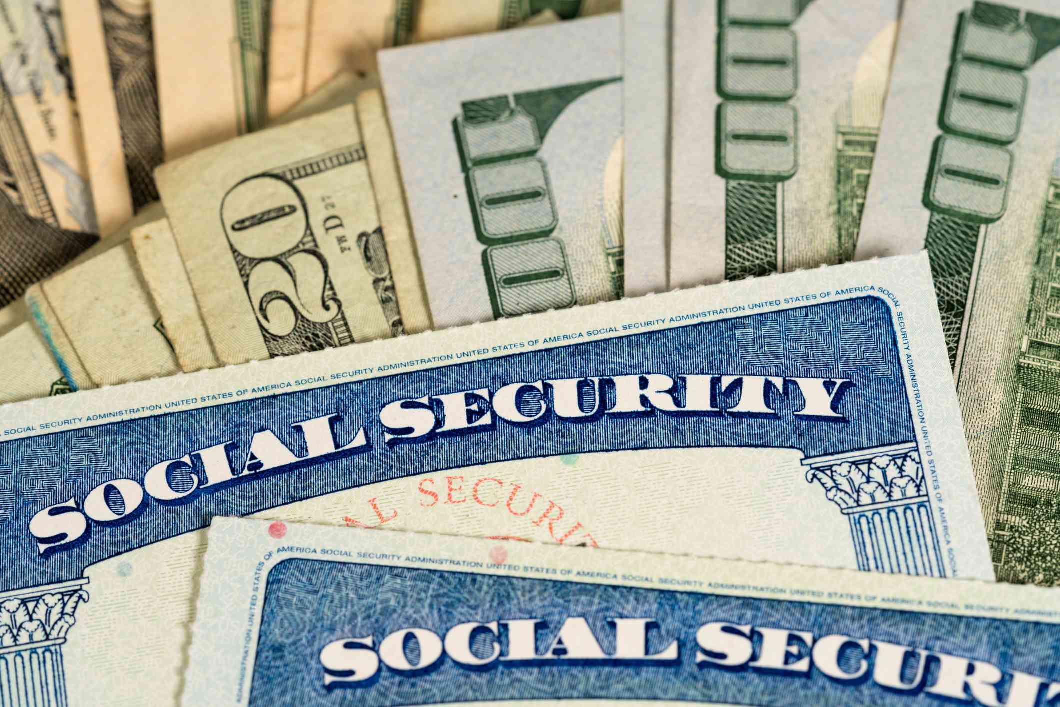 USA Social security cards laid on dollar bills.