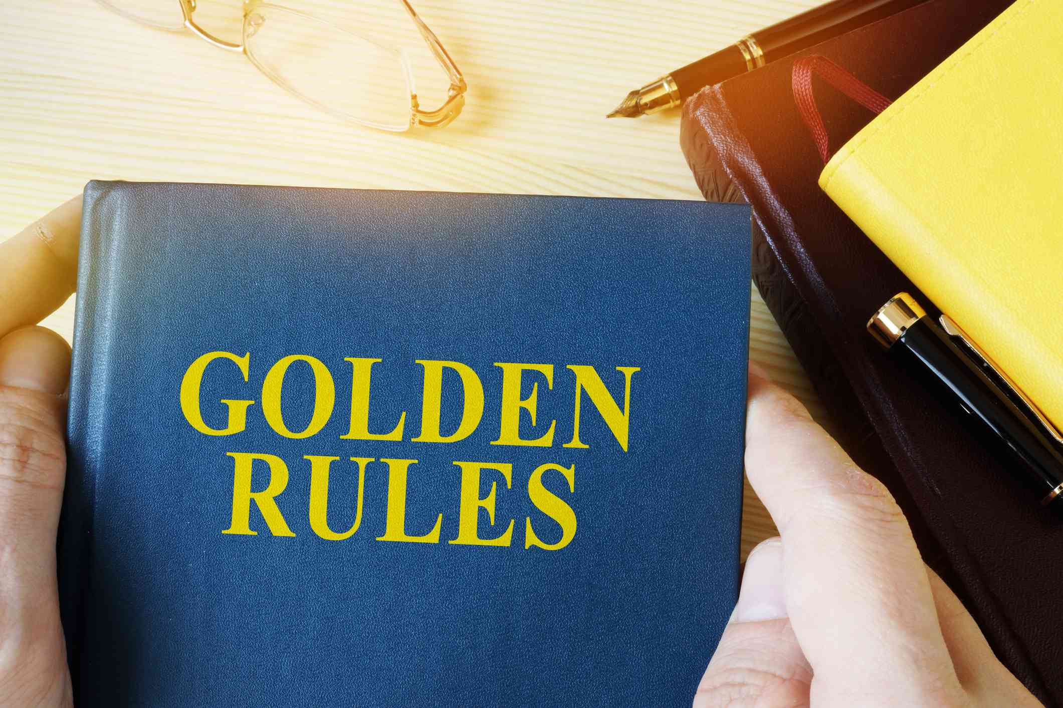 A book labeled golden rules in someone's hands