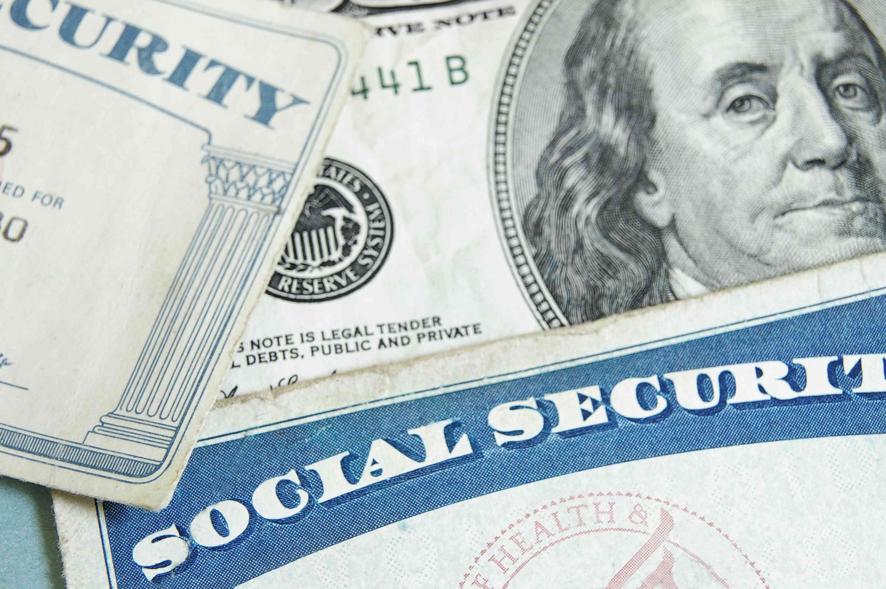 Social Security cards angled on top of a $100 bill