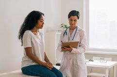 African-American female patient visiting doctor office telling about symptoms